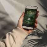 A hand holding a phone showing the Enchanted Forest digital RSVP with its QR reply code
