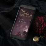 Dark Romance save the date on a phone screen resting on black velvet, with a dahlia and a pocket watch