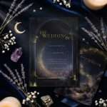Midnight Celestial wedding invitation printed and set beside its companion card, with dried lavender, amethyst and a lit candle