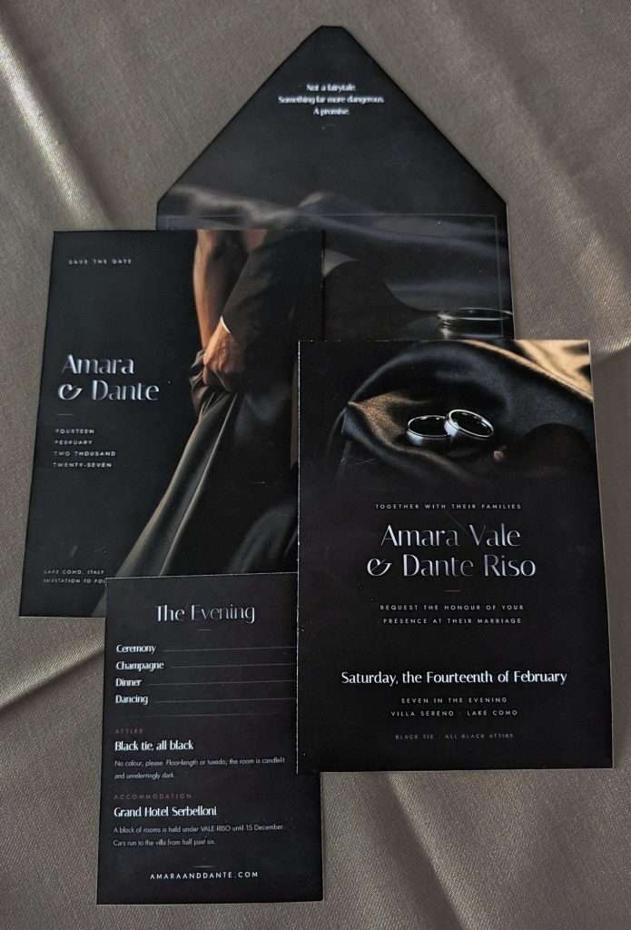 Obsidian Vow Silver suite save the date front showing a hand at the waist of a dark silk gown beside a dinner jacket, photographed next to the wedding invitation and the evening details card.