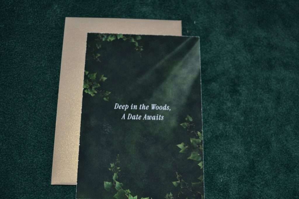Enchanted Forest save the date card back reading Deep in the Woods, A Date Awaits, beside its envelope