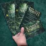 Hand holding the Enchanted Forest invitation, save the date, details card and RSVP