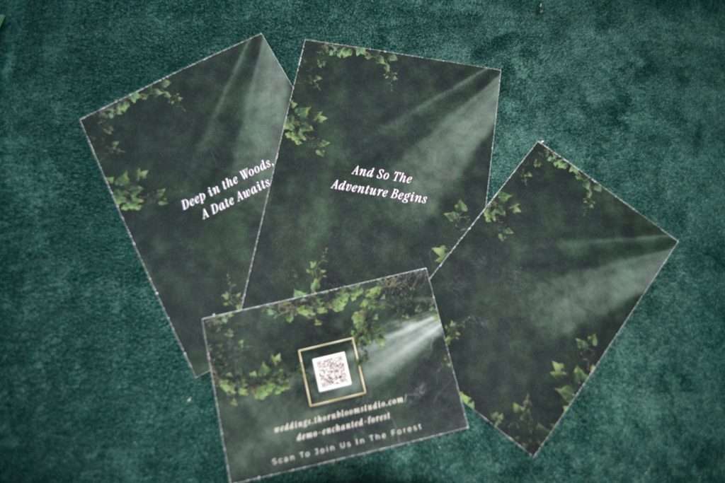 Backs of printed Enchanted Forest stationery pieces including a QR code card