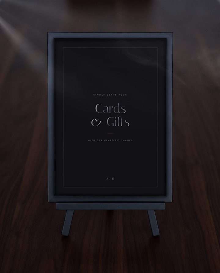 The Obsidian Vow cards and gifts sign framed on a black easel over dark wood