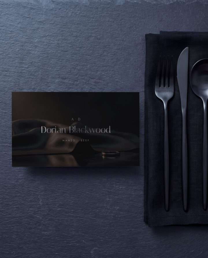 A flat place card, the guest's name and entree set in gunmetal over smoke black