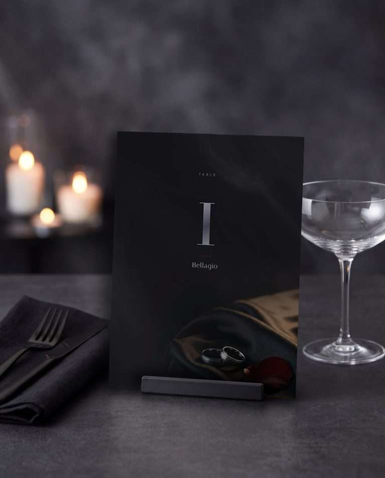 A double-sided table number card in smoke black and gunmetal