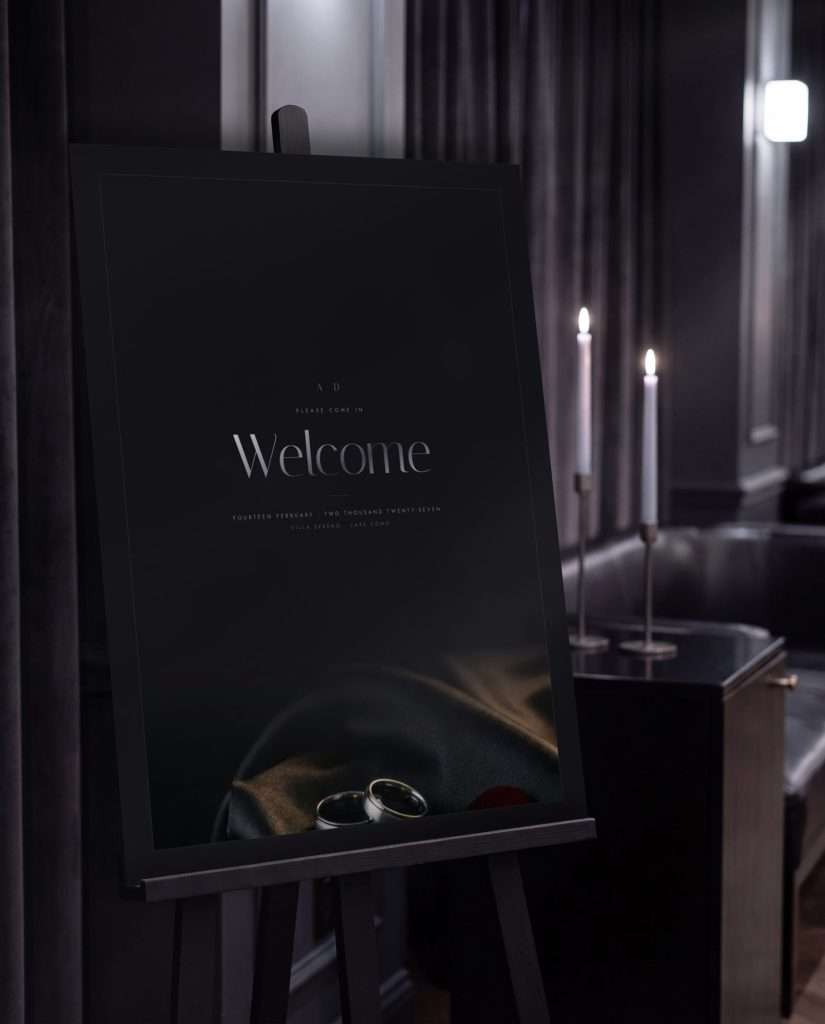 The Obsidian Vow welcome sign at 18 by 24 in a frame on an easel, candlelight behind it. Print mockup.